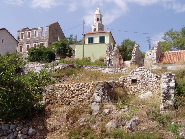 Polorozpadlé domy ve starém městě Podgoře, která se nachází v horách nad novou Podgorou u moře.